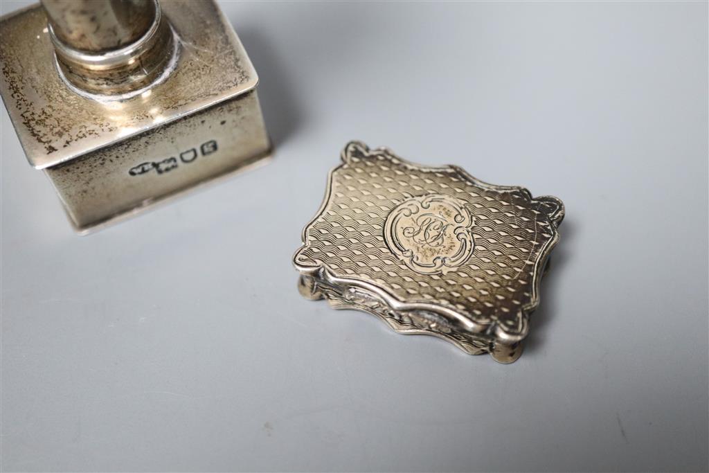 An Edwardian silver stamp press?, William Hornby, London 1902, retailed by Asprey, London, 8cm and a Victorian solver vinaigrette.